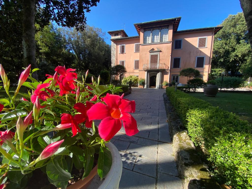 a vase with red flowers in front of a building at Residence Il Fortino in Marina di Massa