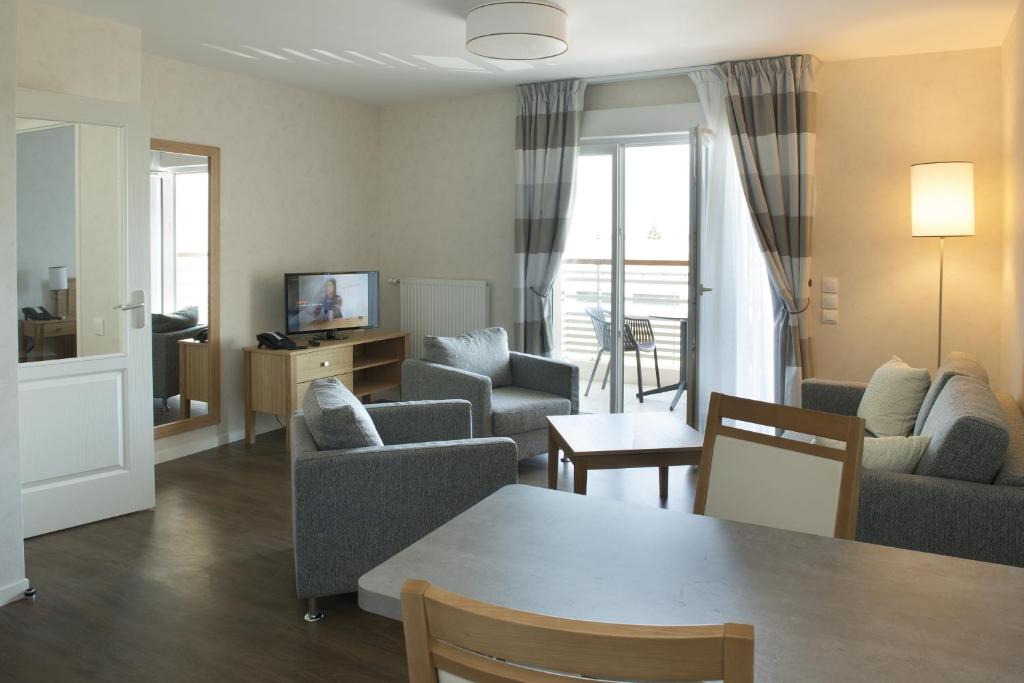 a living room with a table and chairs at Domitys Le Chant des Lavandières in Vernouillet