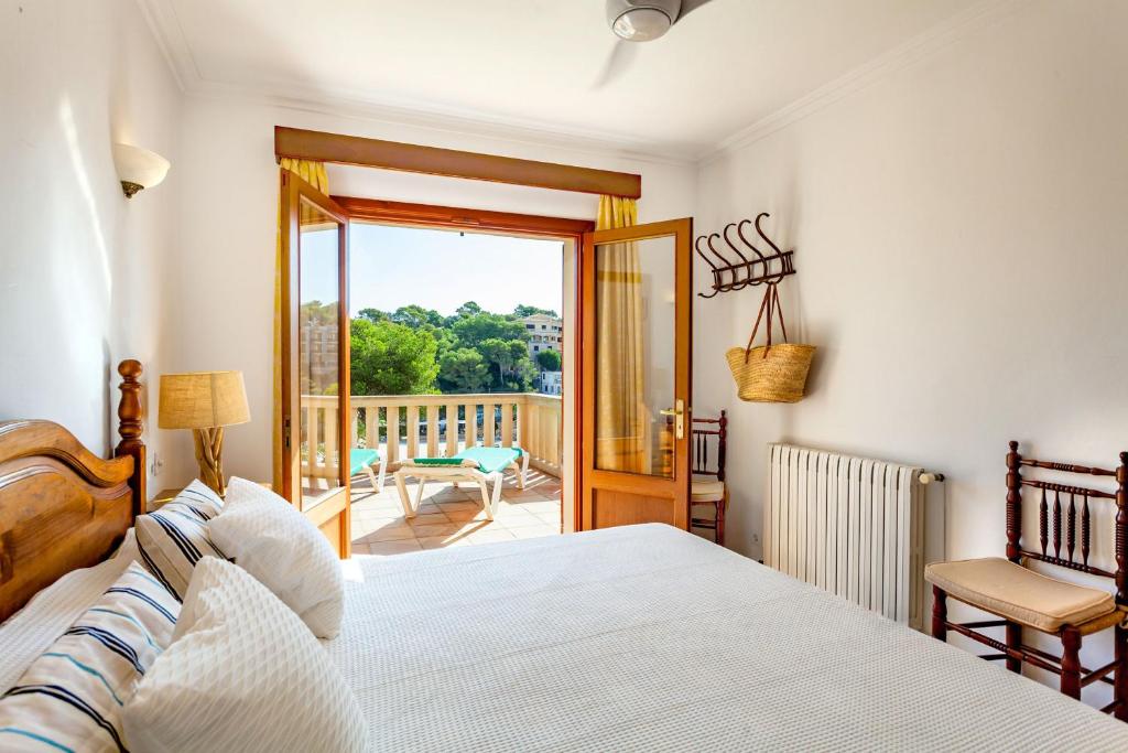 1 dormitorio con 1 cama y balcón en Sa Tronita Beach House, en Cala Santanyi