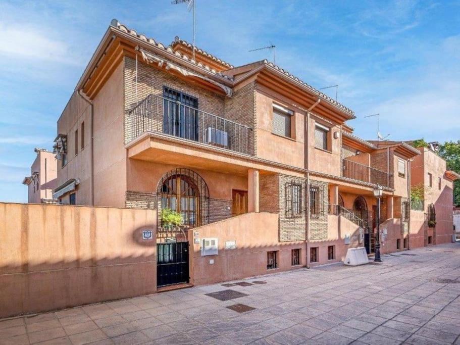 a large brick building with a fence in front of it at Casa independiente en Granada in Granada