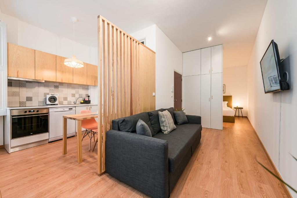 a living room with a couch and a kitchen at GuestReady - Yazdah Flat 3 in Porto