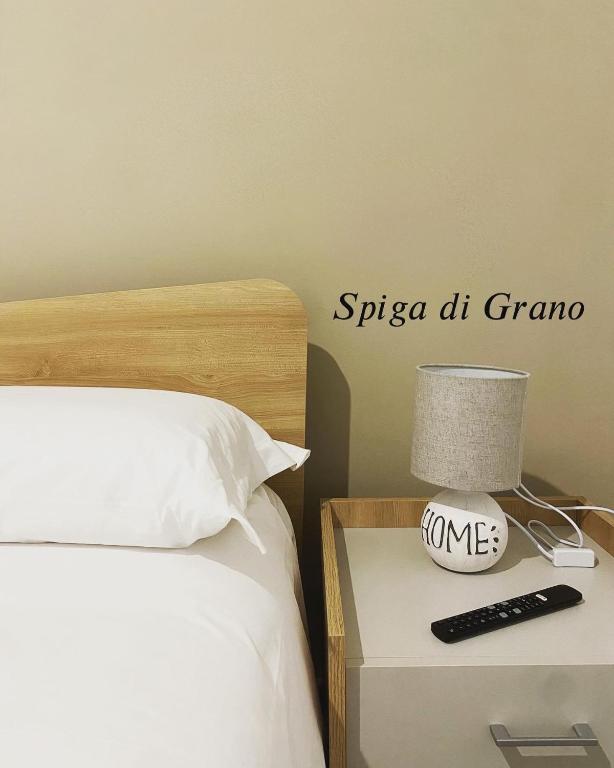 a bed with a nightstand with a lamp and a remote control at Naturelais in Monopoli