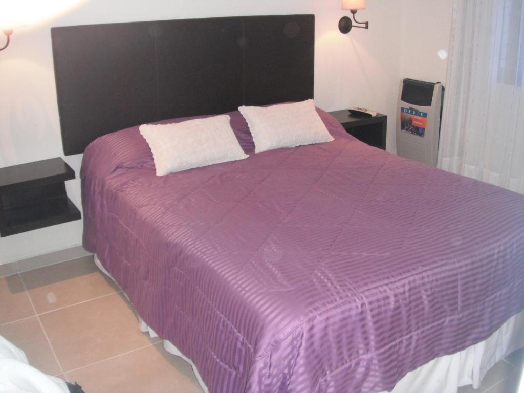 Una cama morada con dos almohadas encima. en Complejo Ayenué & Spa II en Ostende