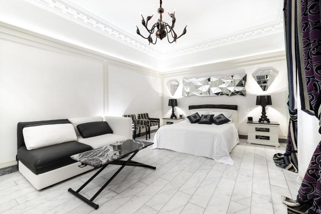 - une chambre blanche avec un lit et un canapé dans l'établissement The Paris Guest, à Paris