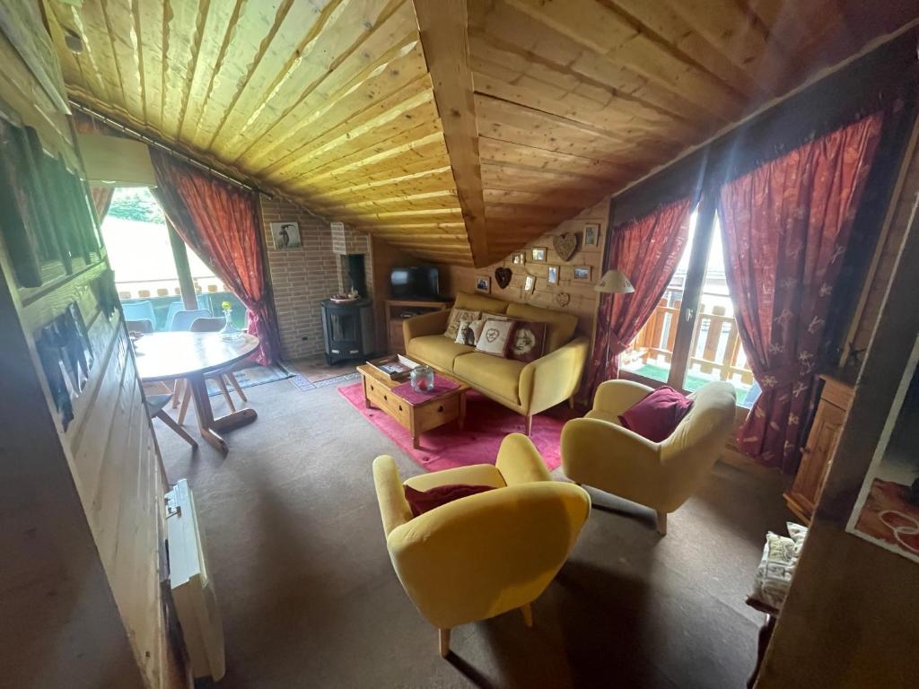 - un salon avec des fauteuils jaunes et un canapé dans l'établissement Bel appartement au décor Montagnard - 80m2, aux Contamines-Montjoie