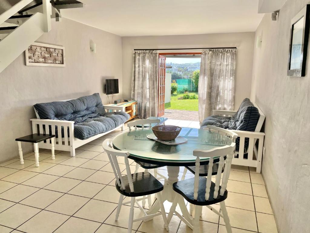 a living room with a table and chairs at 42 Settler Sands Beachfront Accommodation Sea and River View in Port Alfred