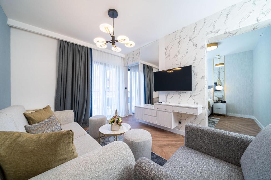 a living room with a couch and a tv at Hotel Millennium by Aycon in Budva
