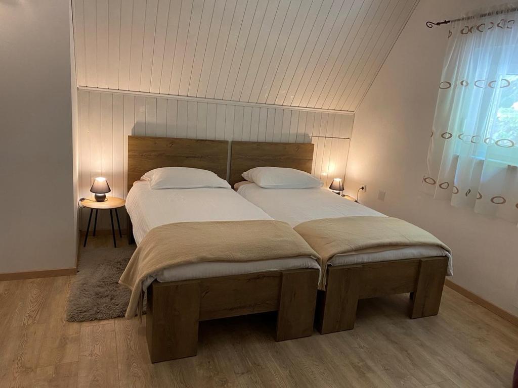 a bedroom with a large bed with white sheets and pillows at Holiday Home Vanda in Zlobin