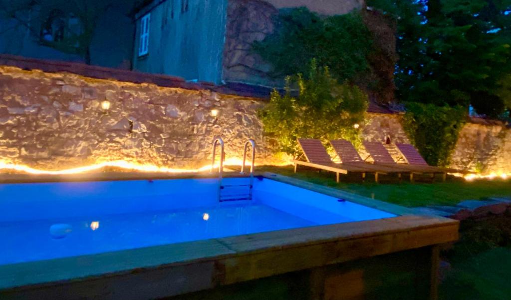 - une piscine avec 2 chaises longues et des piscines dans l'établissement La Villa Alma Colmar, à Colmar