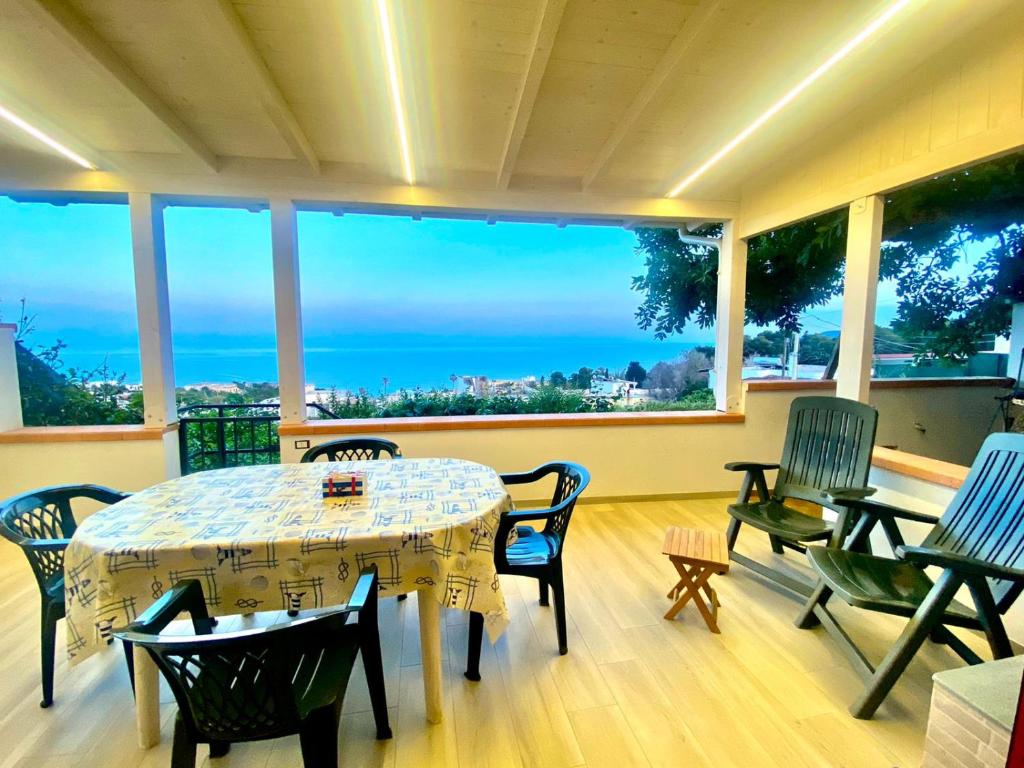 una mesa y sillas en una habitación con vistas al océano en Casa La Quercia, en Marina Porto