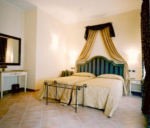 モンテフィアスコーネにあるホテル ウルバーノ Vのベッドルーム(天蓋付きベッド1台付)