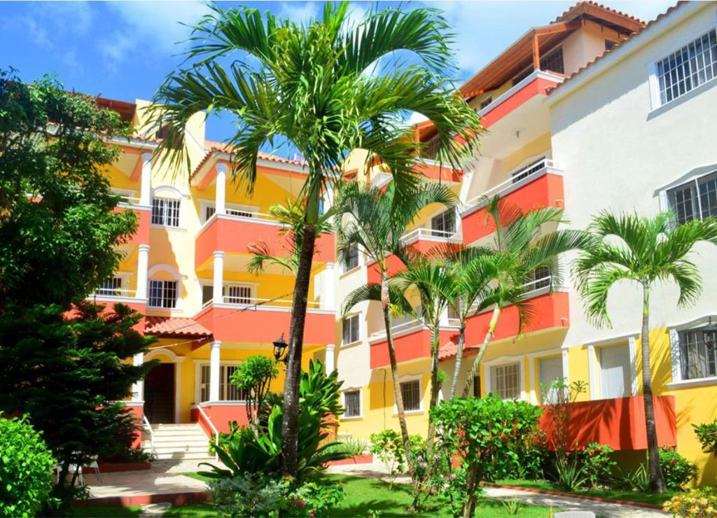 a building with palm trees in front of it at Parco del Caribe in Boca Chica