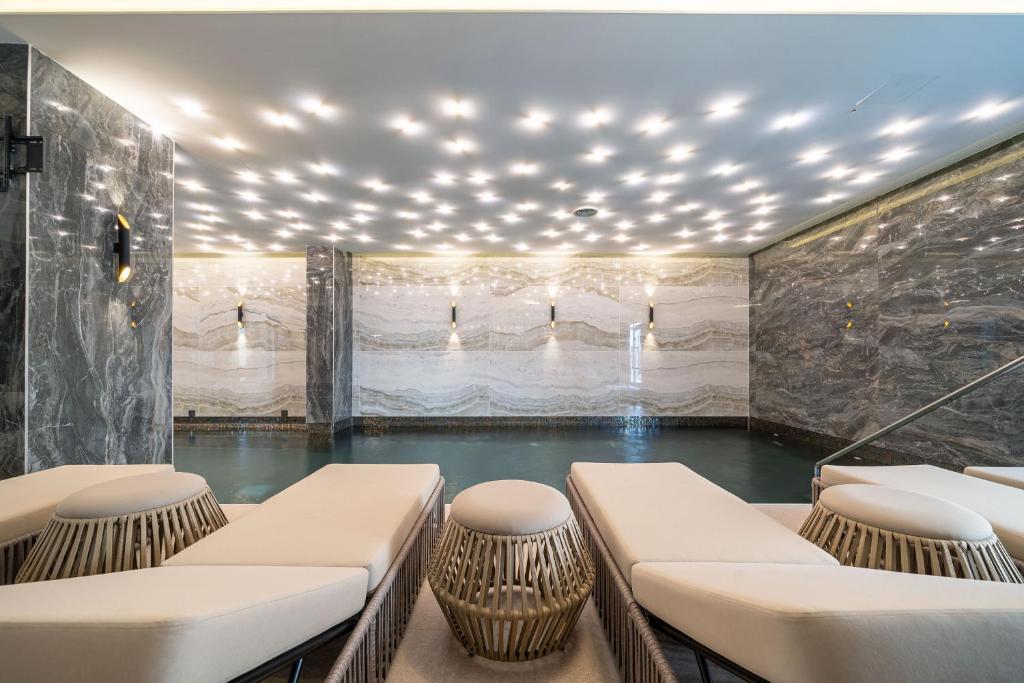 a room with a pool of water with chairs at Hotel Millennium by Aycon in Budva