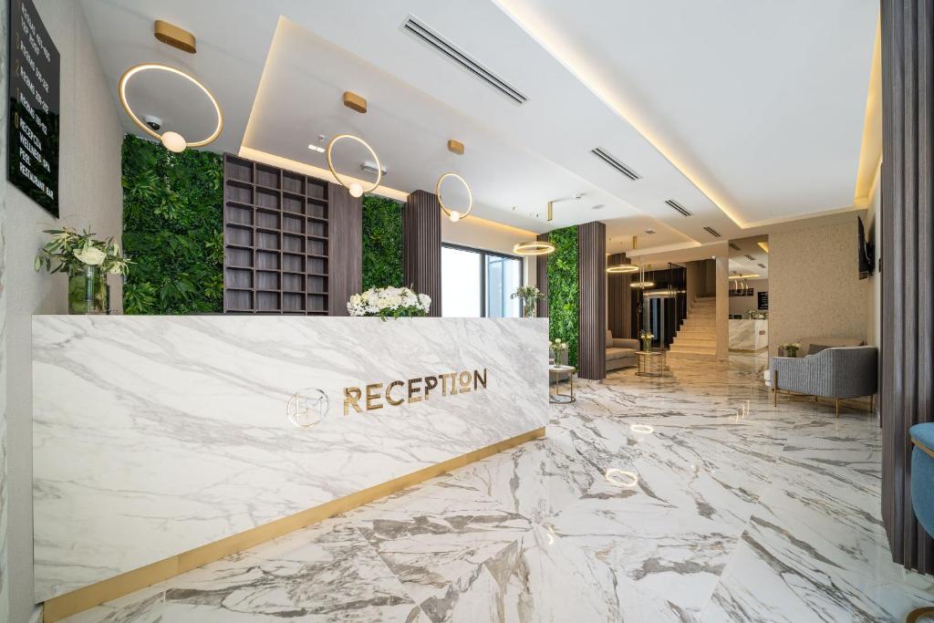 a reception area in a hotel lobby with marble floors at Hotel Millennium by Aycon in Budva