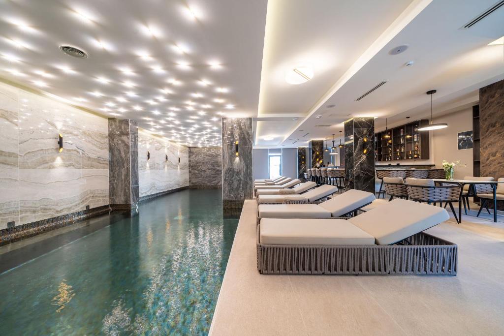 a hotel lobby with a pool and a bar at Hotel Millennium by Aycon in Budva