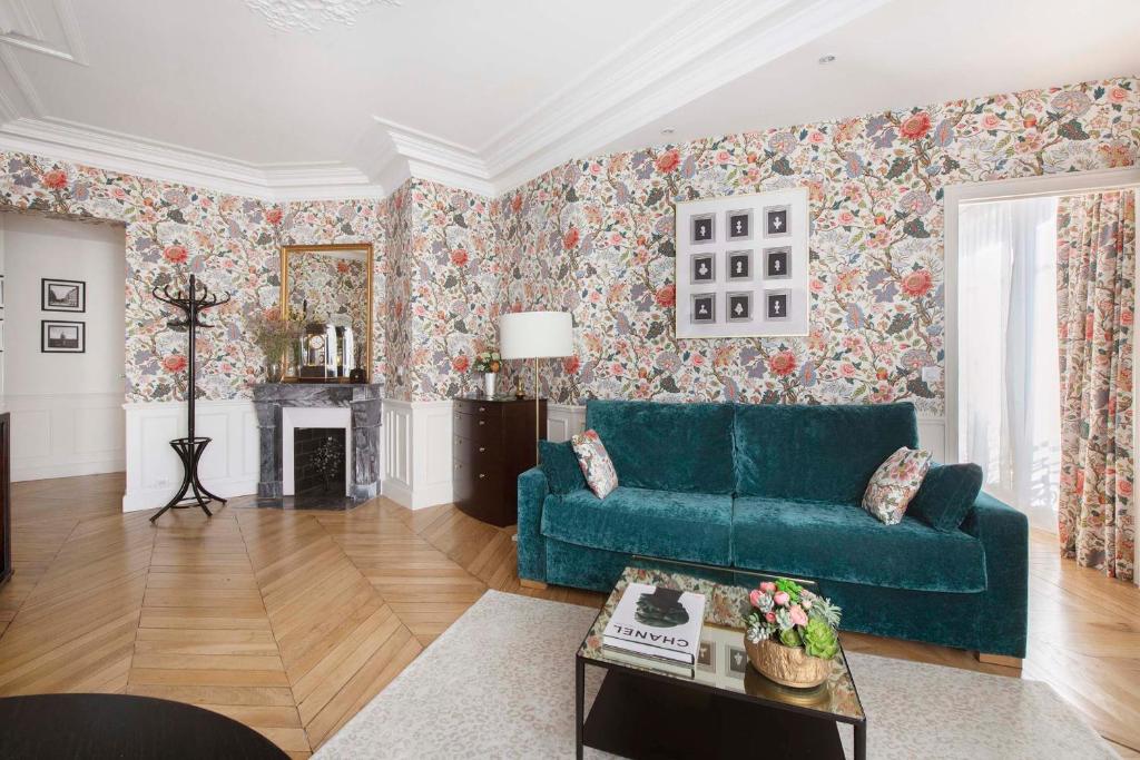 - un salon avec un canapé bleu et du papier peint floral dans l'établissement LE BEAU MARAIS - Luxury Apartments, AIR COND, LIFT, à Paris