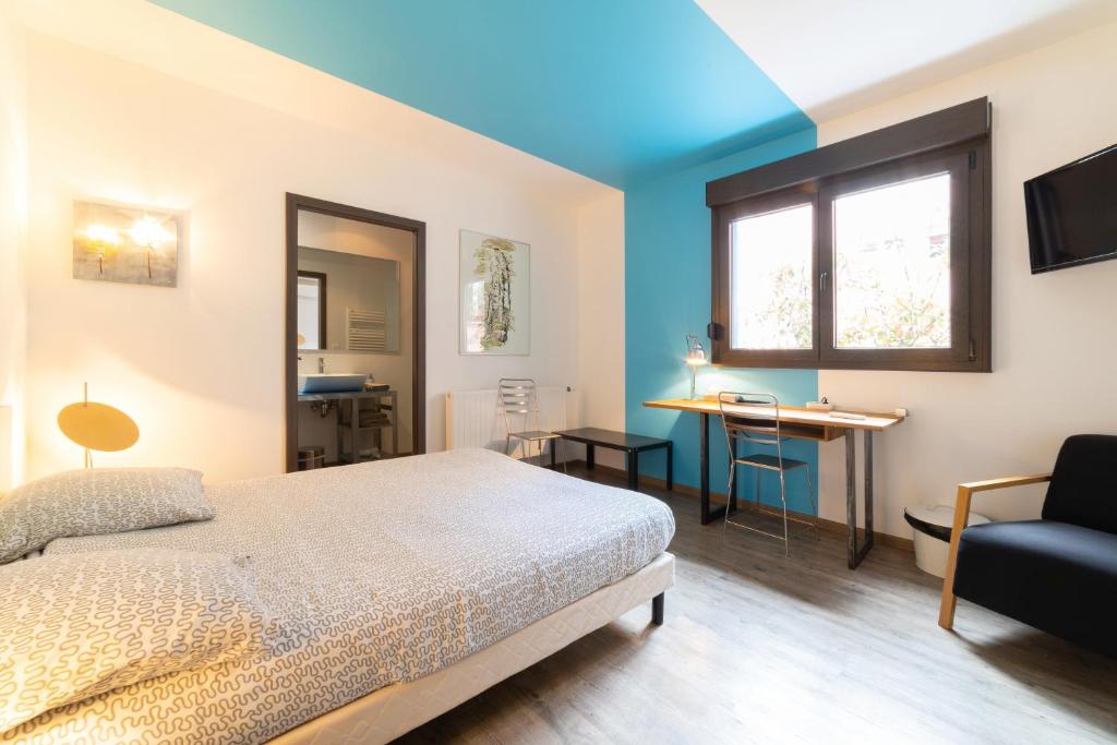 a bedroom with a bed and a desk and a window at Maison Mondrian in Mulhouse