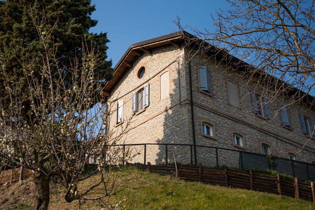 Bebbio的住宿－Casale Monte Valestra，山丘上一座带围栏的大型砖砌建筑
