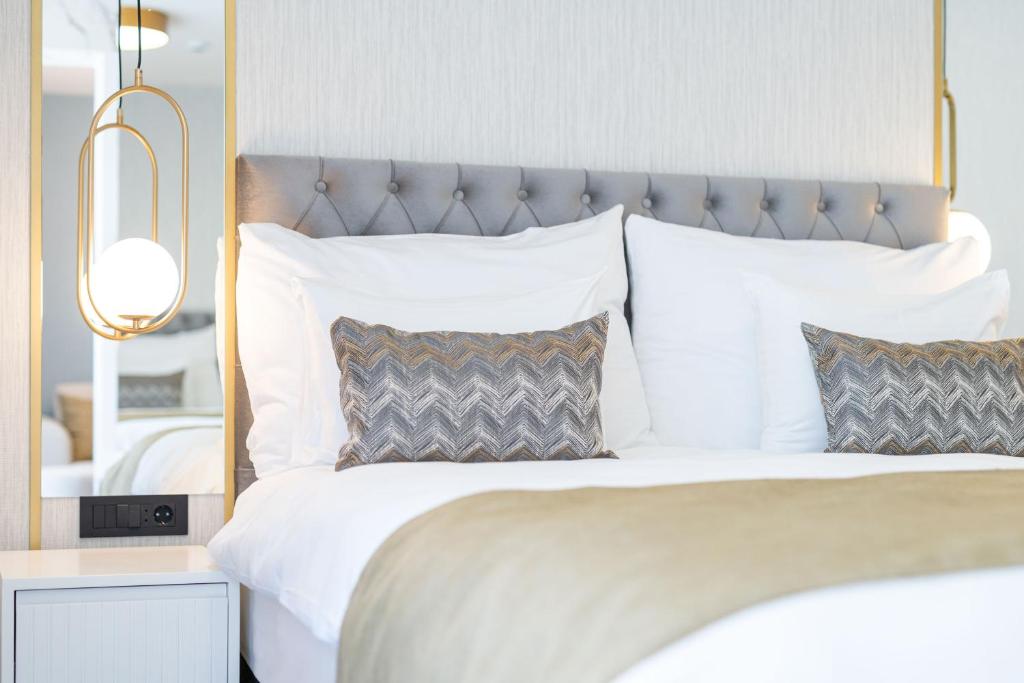 a bedroom with a large bed with white sheets and pillows at Hotel Millennium by Aycon in Budva