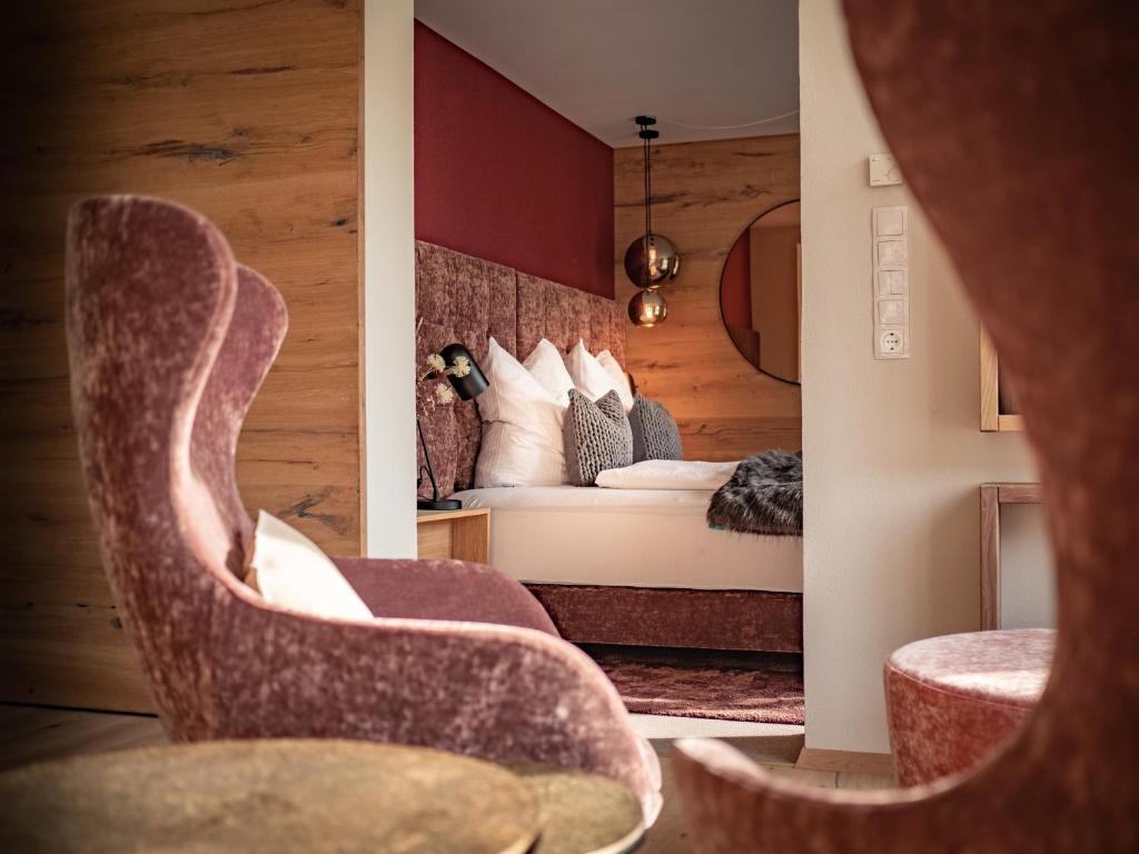 a hotel room with a bed and two chairs at Alpenchalet Vils Tirol in Vils