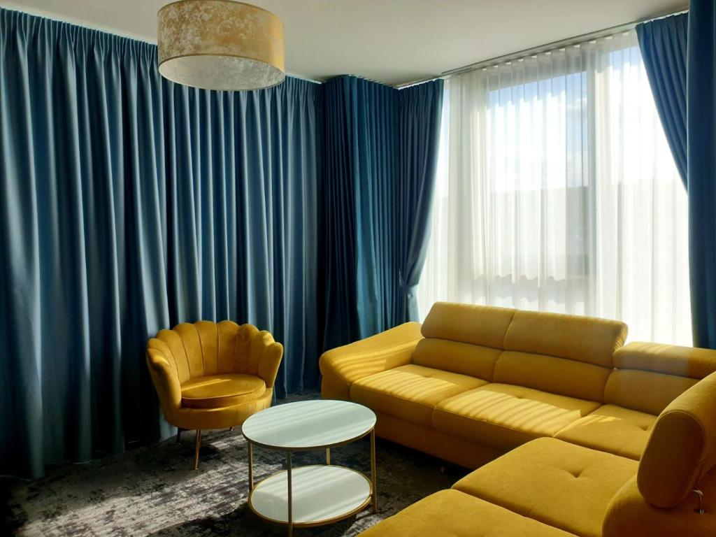 a living room with a yellow couch and a chair at HOTEL ANGEL SOFIA in Fălticeni