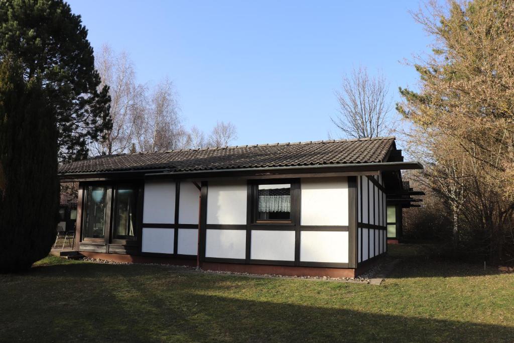 una pequeña casa con pintura blanca y negra en Ferienhaus Robinson Schinderhanneseck 112, en Waldbrunn