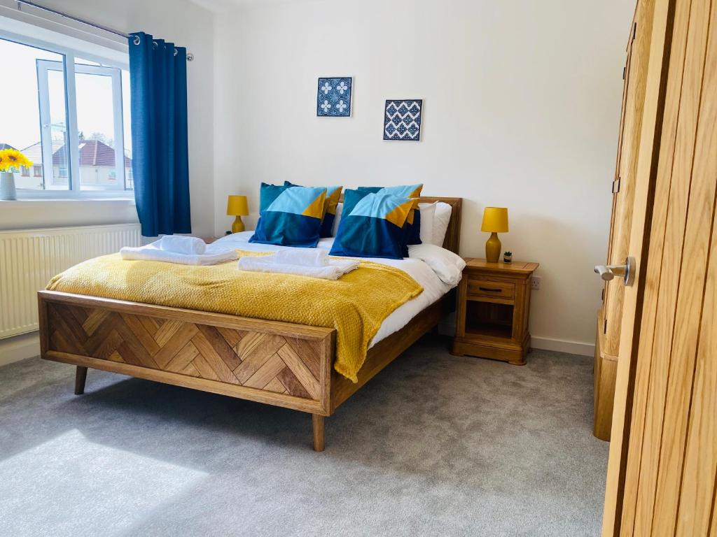 a bedroom with a bed with blue curtains and a window at Modern Family Home with Off-Road Parking in Cardiff