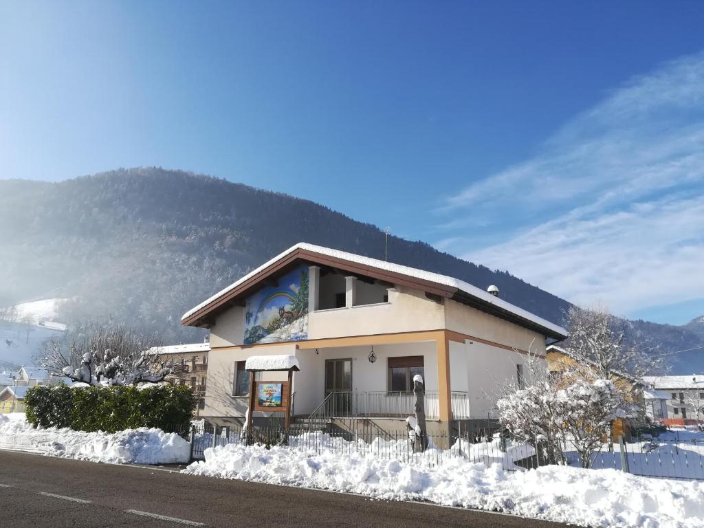 un edificio con nieve alrededor con una montaña en el fondo en LOCAZIONE TURISTICA CASA CITTADELLA, en Arten