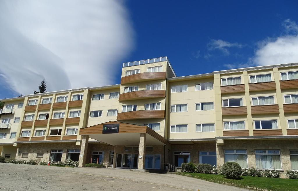 un gran edificio con balcones en un lateral en Huinid Pioneros Hotel en San Carlos de Bariloche