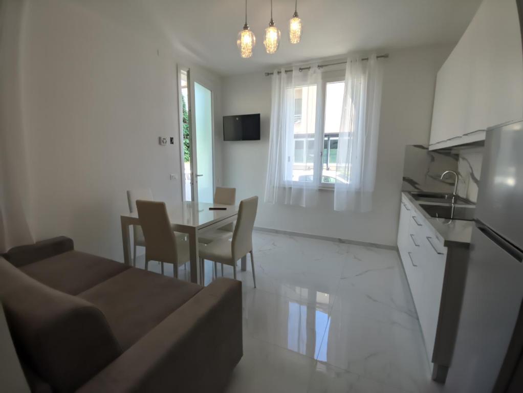 a kitchen and living room with a couch and a table at Villa Cortina in Rimini
