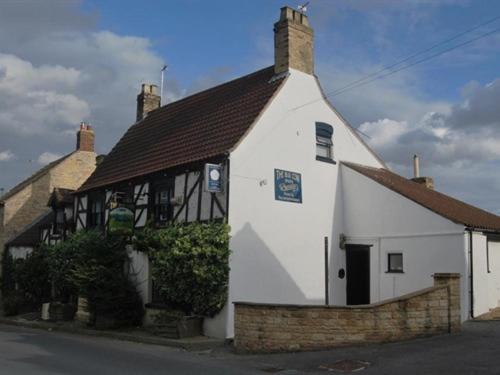 a small white building with a brown roof at The Blue Cow in South Witham