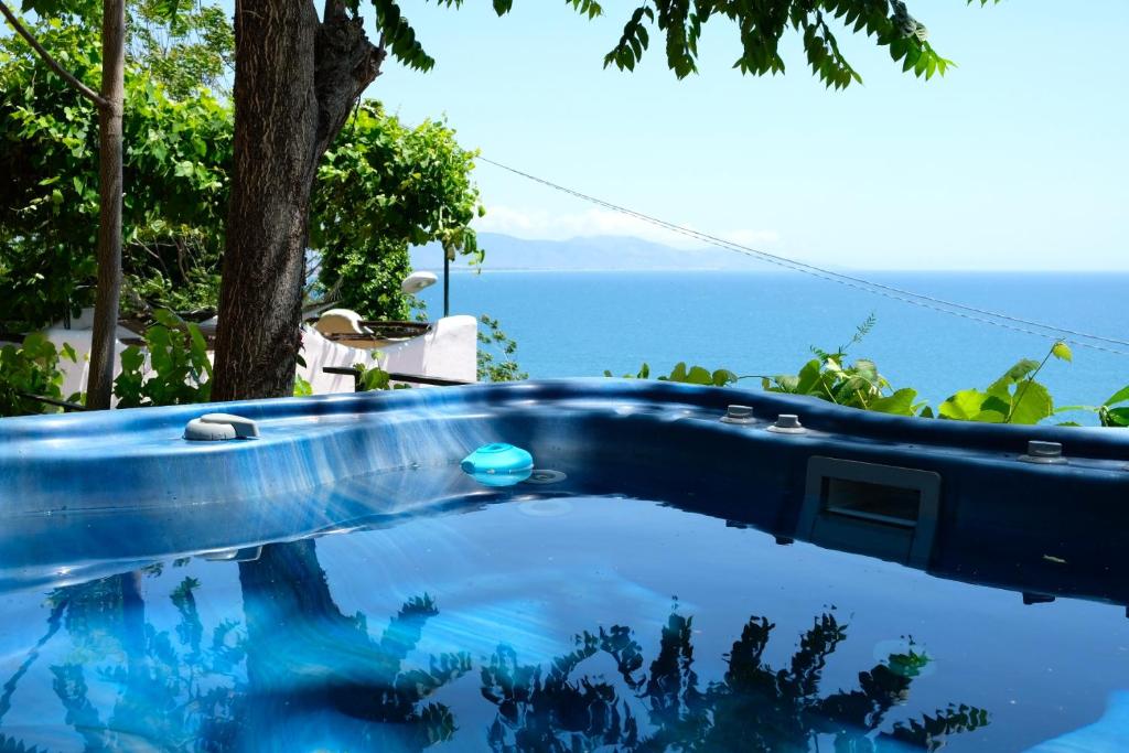 a blue pool with the ocean in the background at Casa Paradiso - Panoramic Sea View & Jacuzzi in Terracina