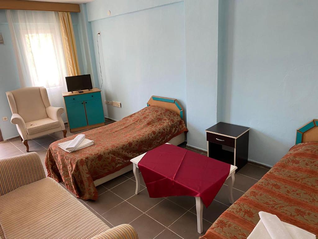 una habitación de hotel con 2 camas y una mesa roja en palm club apart otel, en Kusadasi