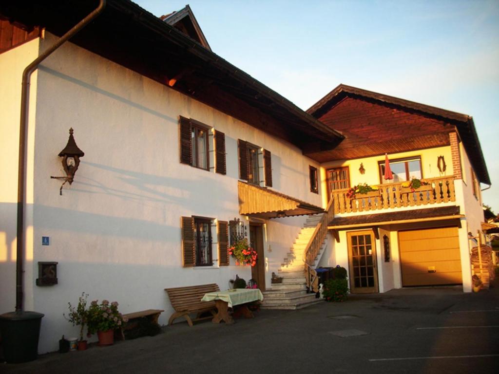 un edificio blanco con un banco delante en Gästehaus zur Brücke en Waging am See