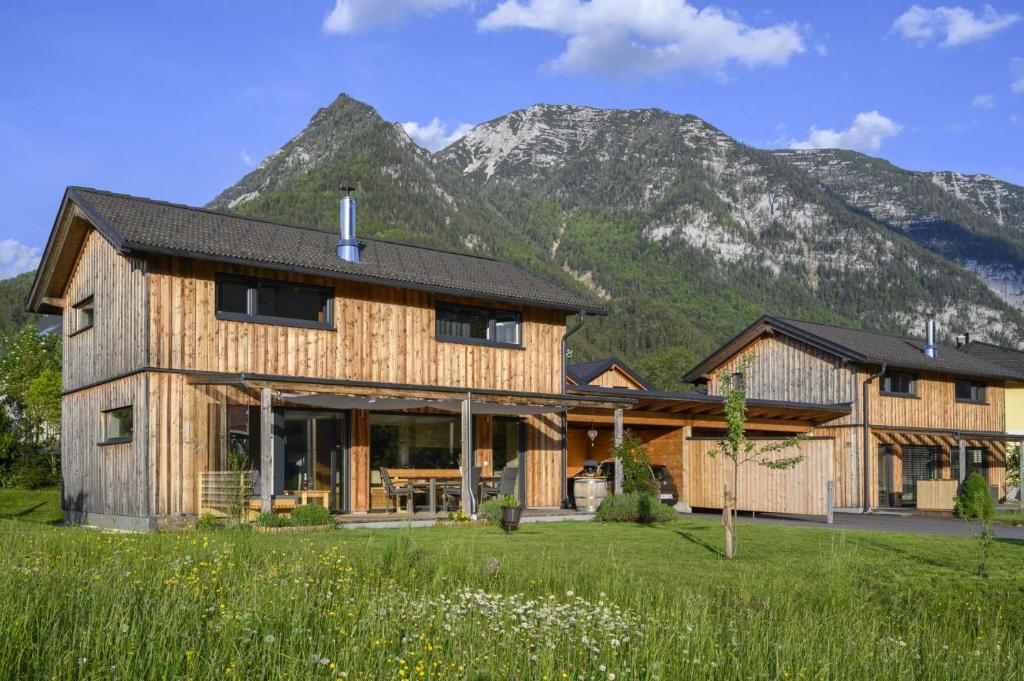 a wooden house with mountains in the background at Ferienlodge MaResi in Bad Goisern