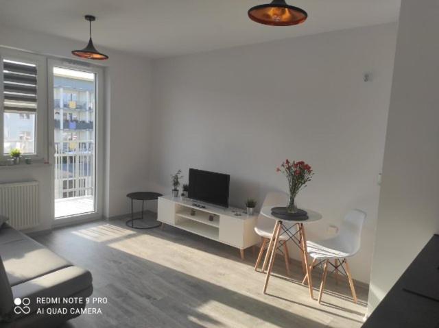 uma sala de estar com uma televisão e uma mesa e cadeiras em Apartament z Jacuzzi i Sauna em Radom
