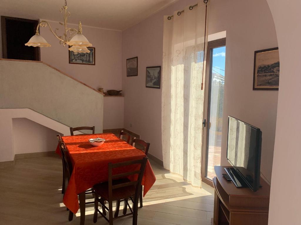 une salle à manger avec une table rouge et une télévision dans l'établissement Etna-Dimora-Dei-Saponari, à Trecastagni