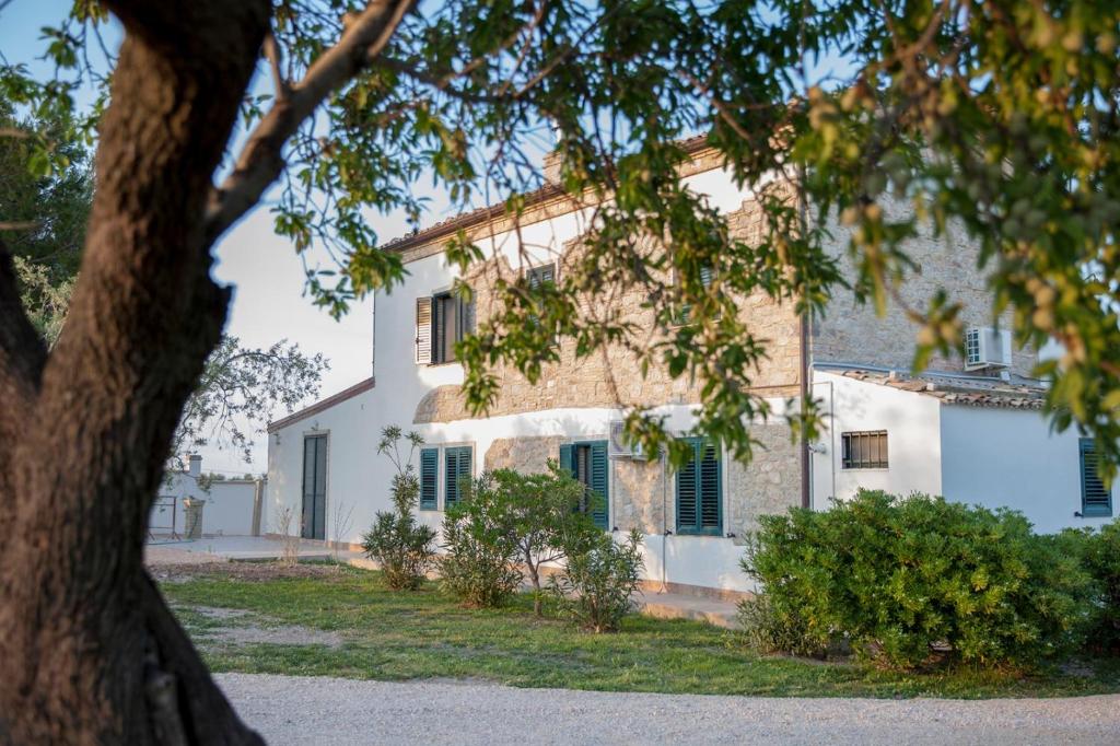 een wit huis met een boom ervoor bij Masseria Piana Cimino in Pietra Montecorvino