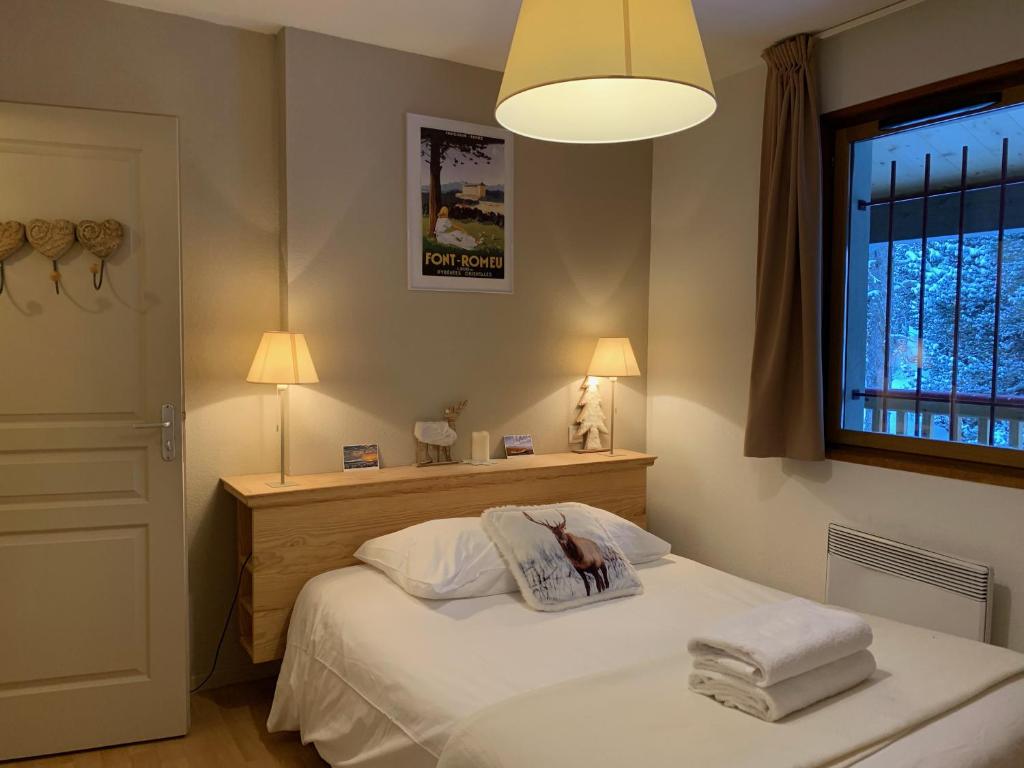 1 dormitorio con 1 cama con sábanas blancas y ventana en Font -Romeu : Beau T4 avec parking, terrasse et vue, en Font-Romeu-Odeillo-Via