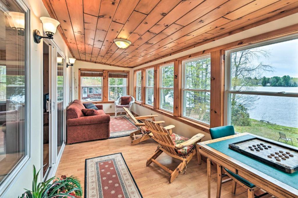 a screened in porch with a table and chairs at Lakefront Broadalbin Getaway with Deck and Kayaks in Broadalbin