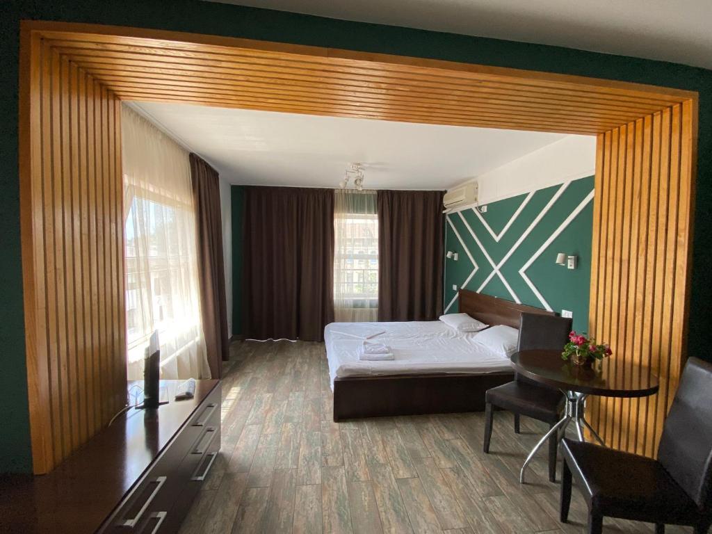 1 dormitorio con 1 cama y 1 mesa en una habitación en Ave Hotel Victoriei, en Bucarest