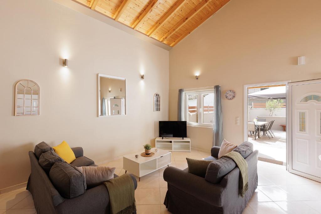 a living room with two couches and a television at Mythos Modern Loft in Dassia