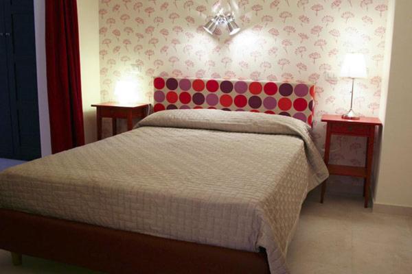 1 dormitorio con 1 cama con cabecero rosa y morado en In City-In, en Catania