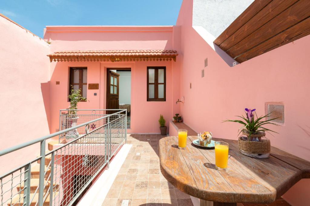 a balcony with a wooden table and orange juice at Ey Sofias Suites in Rhodes Town