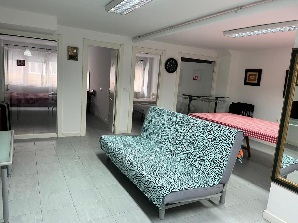 - un salon avec un canapé bleu et un lit dans l'établissement Loft en Torrelavega, à Torrelavega