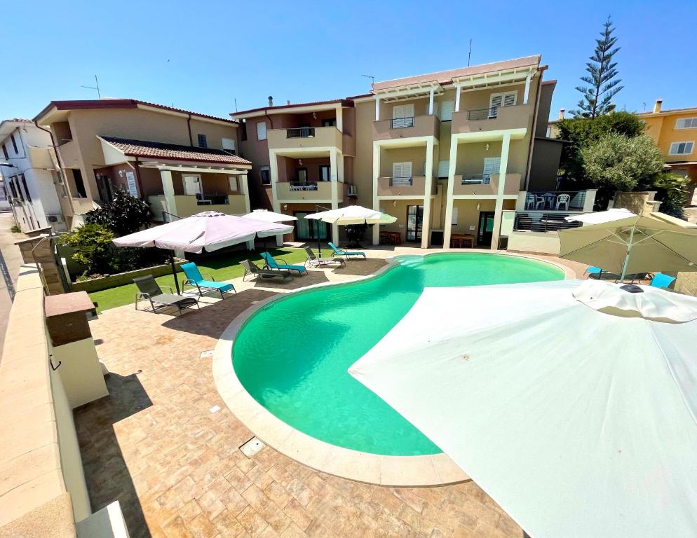 ein Pool mit Sonnenschirm und ein Gebäude in der Unterkunft Apartment Romina in Tergu