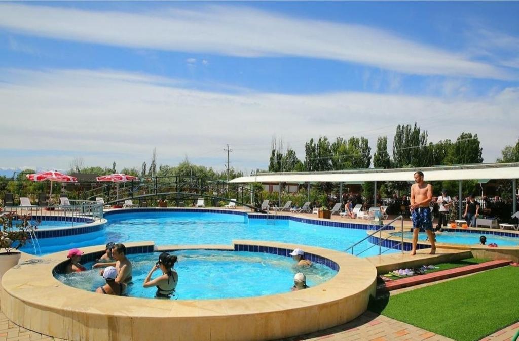 un grupo de personas en una piscina en un complejo en Квартира в Радуга WEST en Koshkolʼ