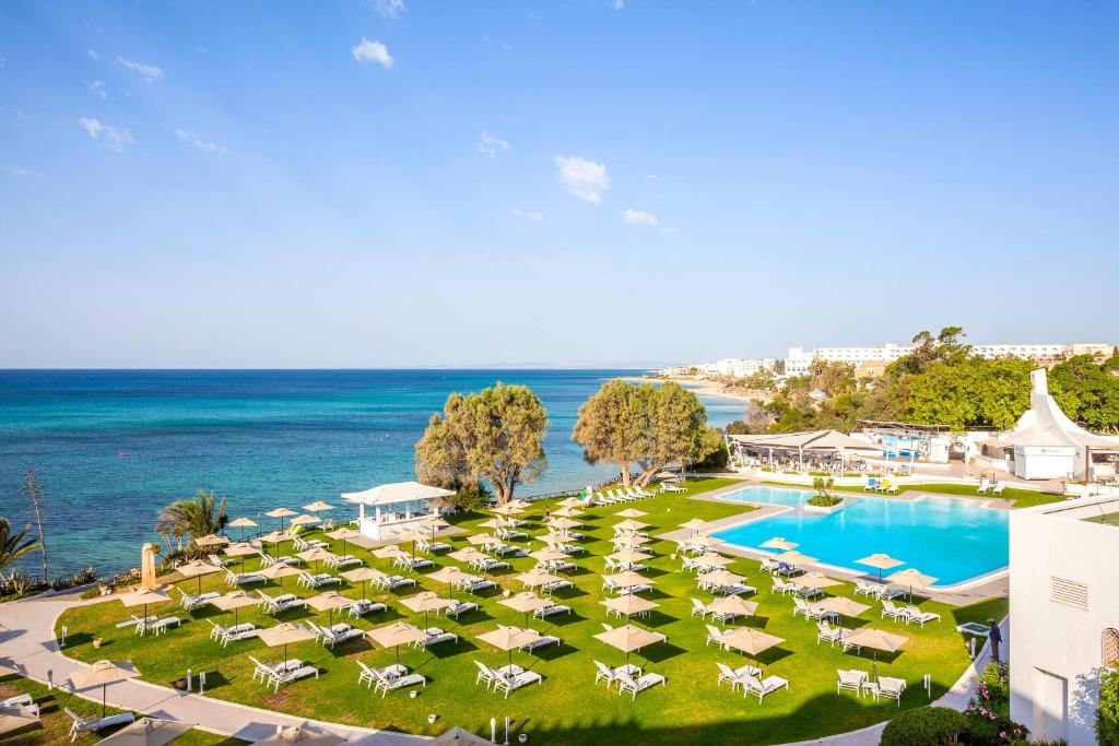 an aerial view of a resort with a swimming pool and the ocean at Le Sultan in Hammamet