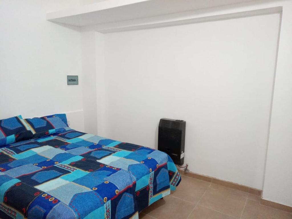 a bedroom with a bed with a blue comforter at CENTENO CASI 9 DE JULIO in Santa Rosa