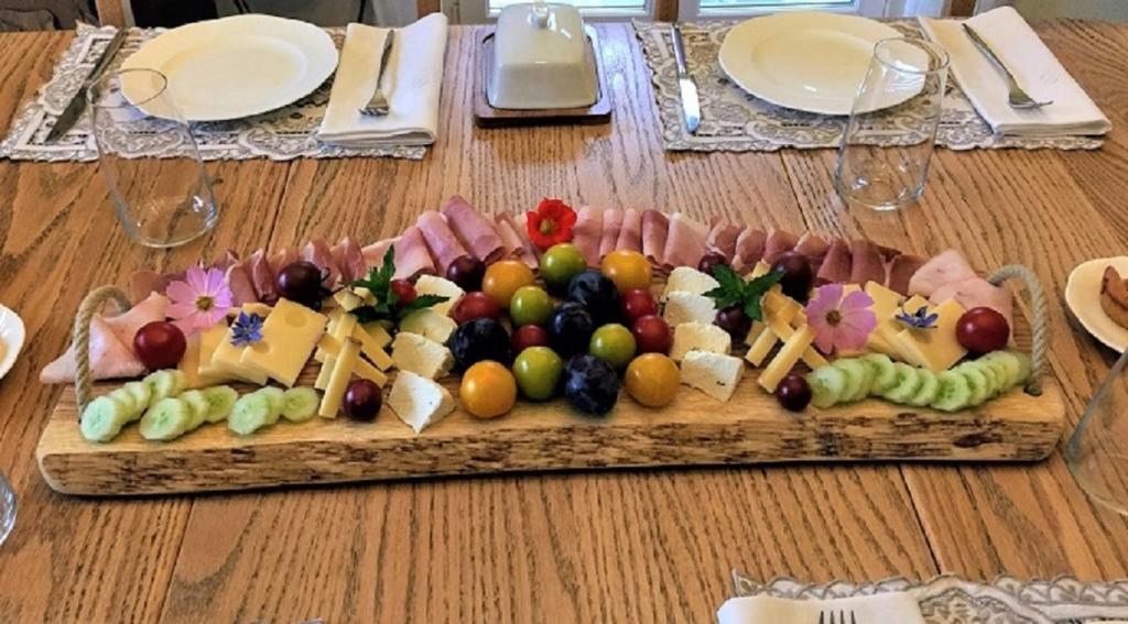 - un plateau de fromage et de fruits sur une table en bois dans l'établissement B&B Mon Rêve, Petit déjeuner BIO, Jacuzzi, à Les Evouettes 